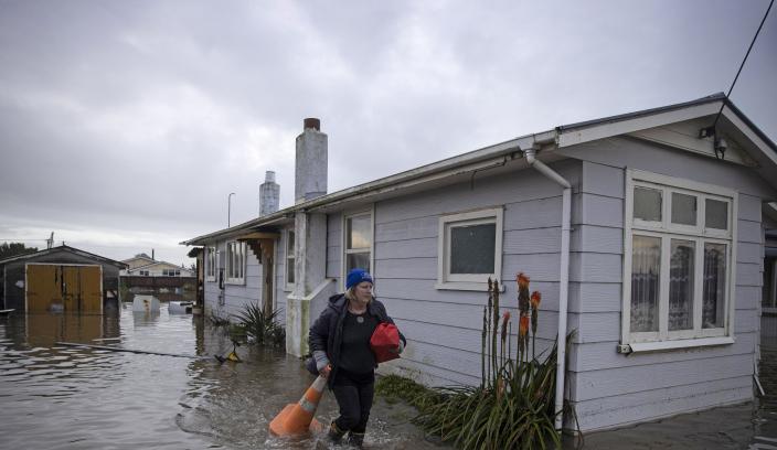 A resident leaves her home after the flood